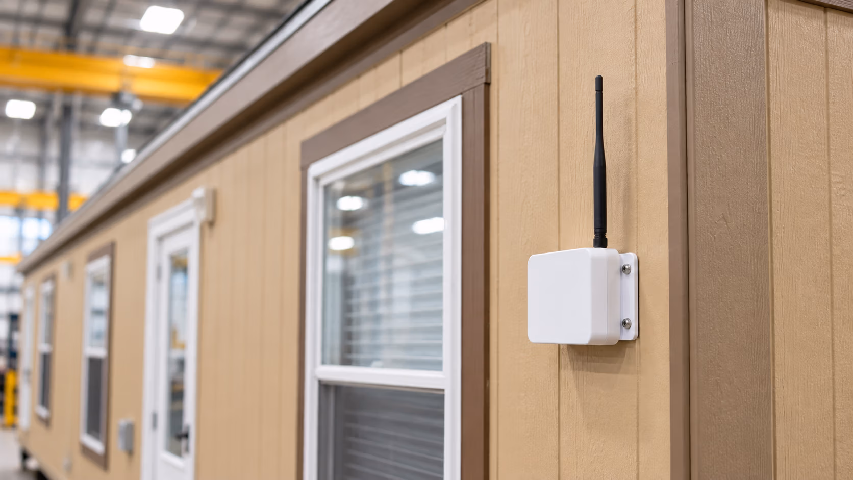 Wireless monitoring gateway mounted on the exterior of a workforce housing unit.